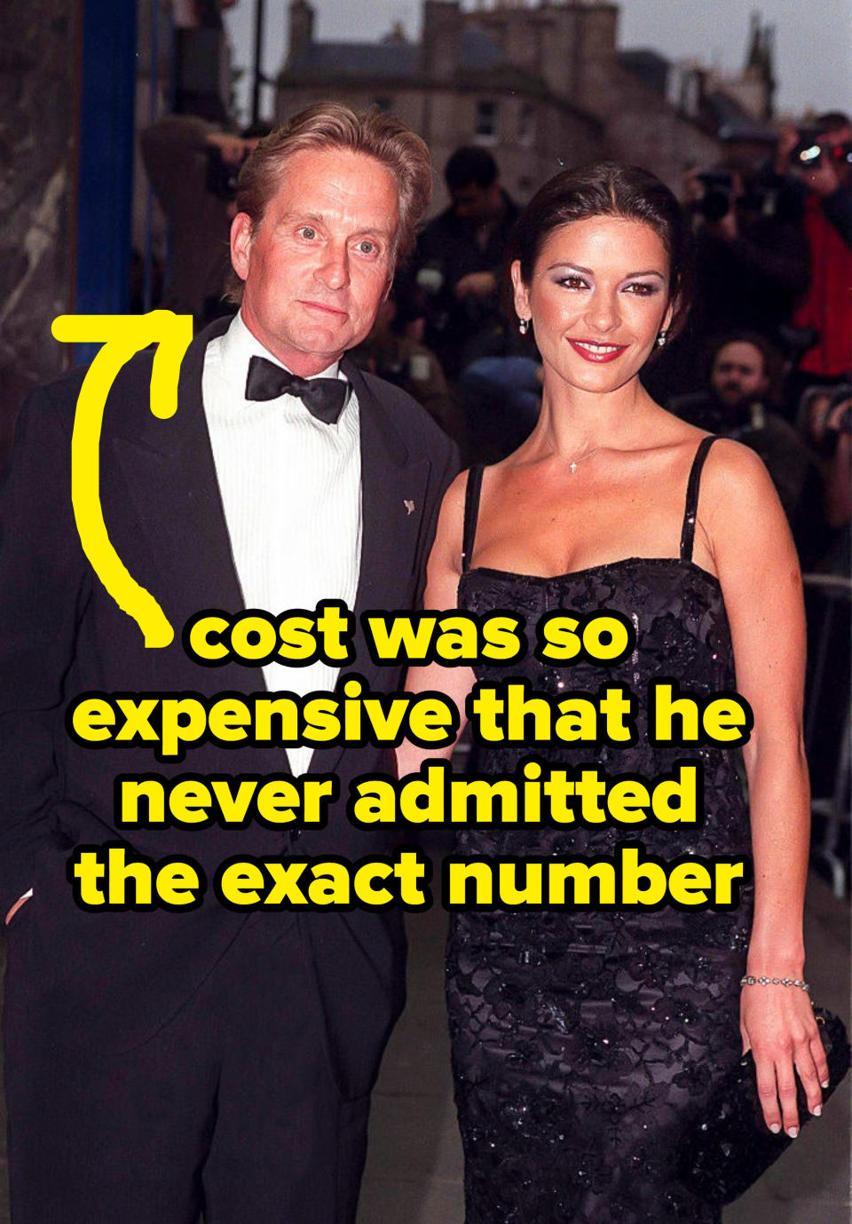Michael Douglas and Catherine Zeta-Jones at an event with text pointing at Douglas that reads, "Cost was so expensive, he never admitted the exact number"