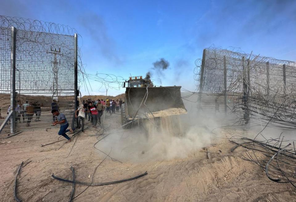 A bulldozer at a border fence