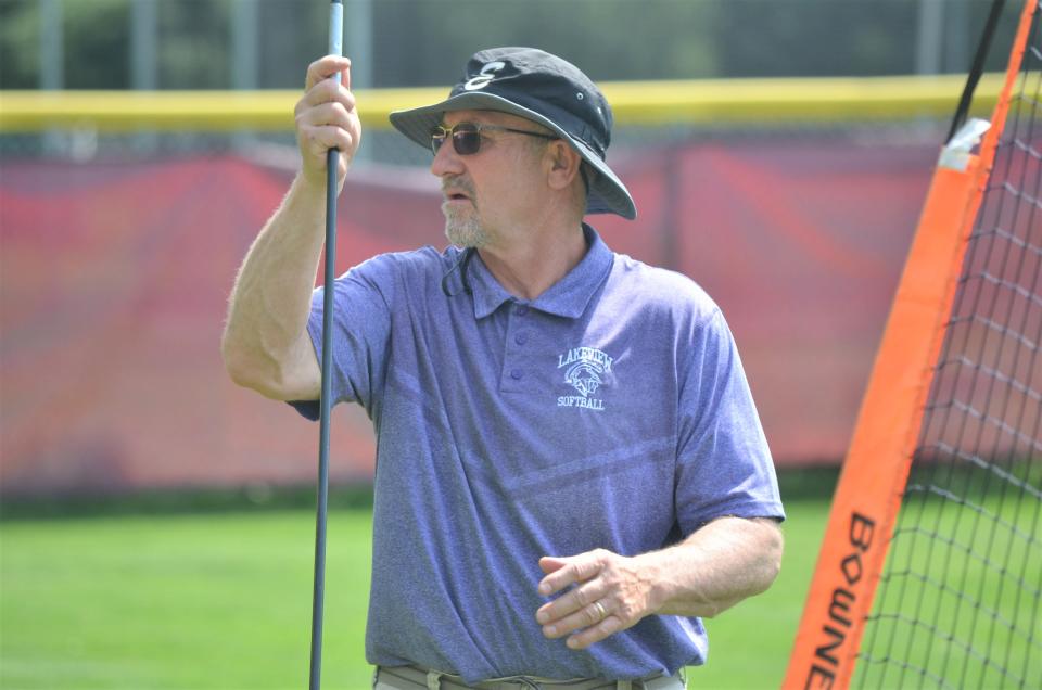 Lakeview head coach Brian Ratliff sets up equipment before playing a game against Kalamazoo Central, which is coached by his son Tyrus Ratliff.