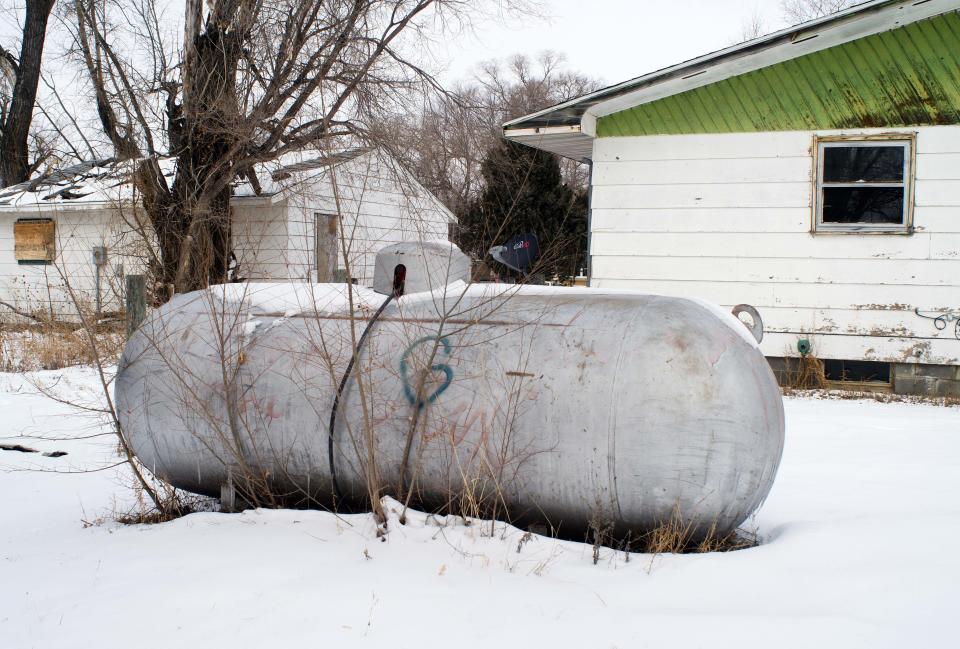 In this Thursday, Feb. 6, 2014 photo is a propane tank outside a home on the Standing Rock Reservation in Fort Yates, N.D. The reservation is on the wind-swept Northern Plains where there is little to block the icy gales that whip in from the northwest and create wind chills as low as 50 below. Many residents live in homes, some with ill-fitting doors, others with boards tacked up where the windows should be, or deteriorating roofs that leak much-needed warmth. (AP Photo/Kevin Cederstrom)