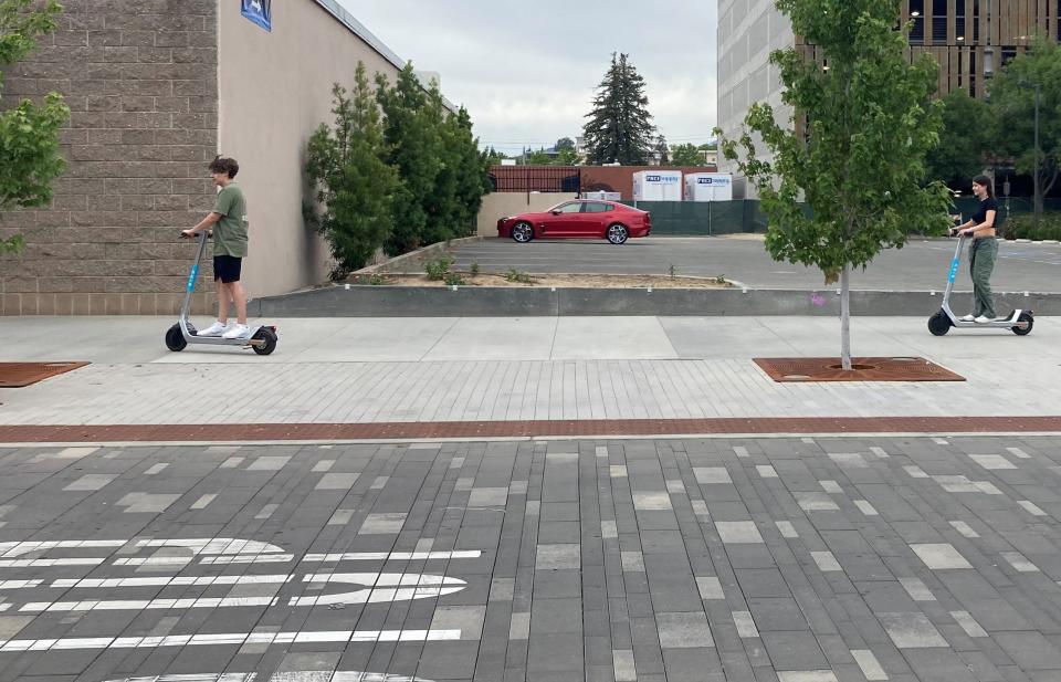 Christian Boehme and Makyna Laeber ride scooters around downtown Redding on Sunday. The high temperature reached 80 degrees Sunday, 18 degrees off the normal for the date.