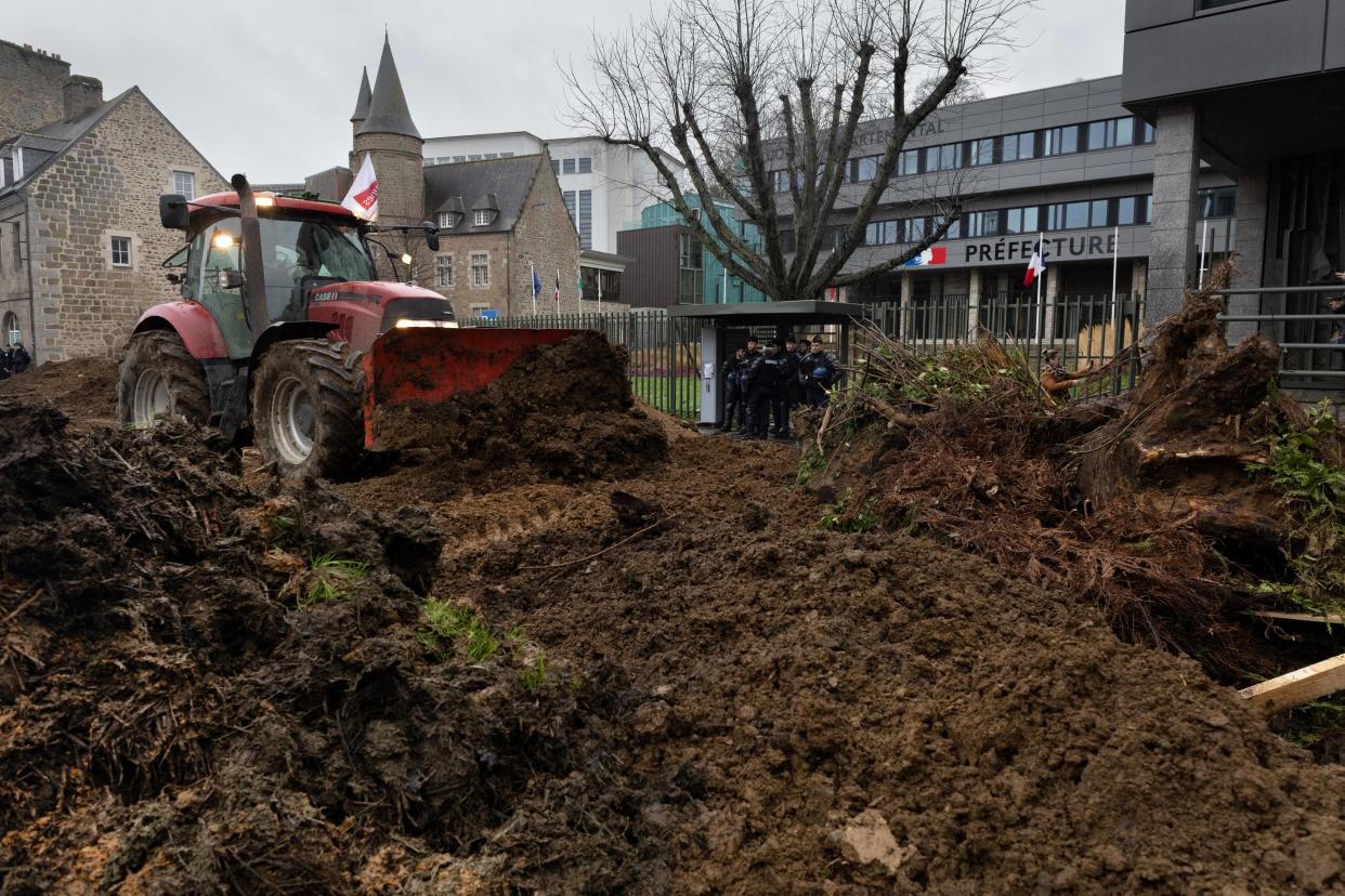 Des agriculteurs déversant de la terre devant la préfecture des Côtes-d’Armor à Saint-Brieuc, le 21 février 2024.