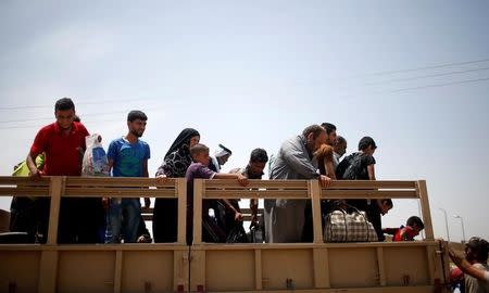 Displaced Iraqis get out a military truck as Iraqi forces battle with Islamic State militants, in western Mosul, Iraq May 10, 2017. REUTERS/Suhaib Salem