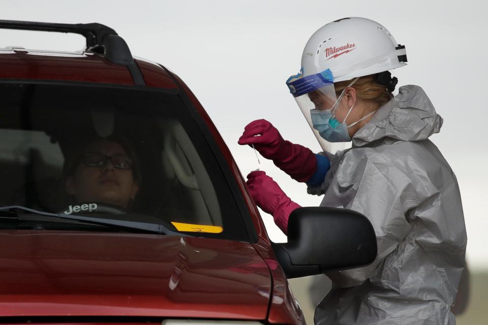 Kansas National Guard member Jessica Pal collects a sample at a drive-thru COVID-19 testing site May 20 in Dodge City, Kan. Army and Air Force medical guard units have tested 100-200 people daily.