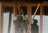 Beach hotel workers cover doors and windows with plywood as they prepare for the arrival of Tropical Storm Zeta in Playa del Carmen, Mexico, Monday, Oct. 26, 2020. A strengthening Tropical Storm Zeta is expected to become a hurricane Monday as it heads toward the eastern end of Mexico's resort-dotted Yucatan Peninsula and then likely move on for a possible landfall on the central U.S. Gulf Coast at midweek. (AP Photo/Tomas Stargardter)