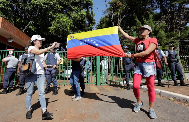 Supporters of Venezuela's President Nicolas Maduro hold a flag outside Venezuelan embassy in Brasilia