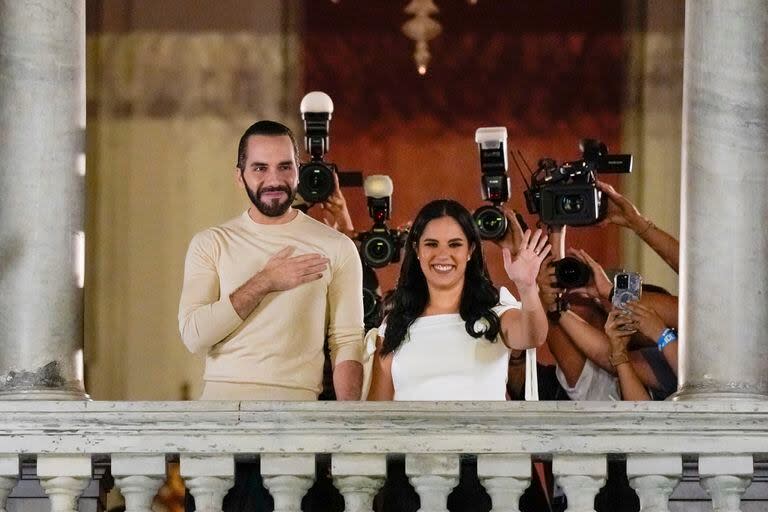 El presidente de El Salvador, Nayib Bukele, acompañado por su esposa Gabriela Rodríguez, saluda a sus seguidores desde el balcón del palacio presidencial en San Salvador, después del cierre de las urnas para las elecciones generales del domingo 4 de febrero de 2024