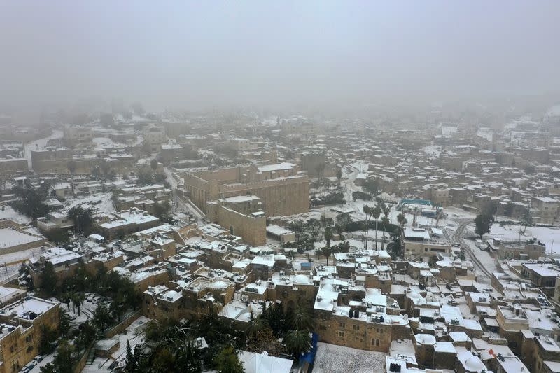 A picture taken with a drone shows roofs of buildings and houses covered with snow following snowfall in Hebron in the Israeli-occupied West Bank