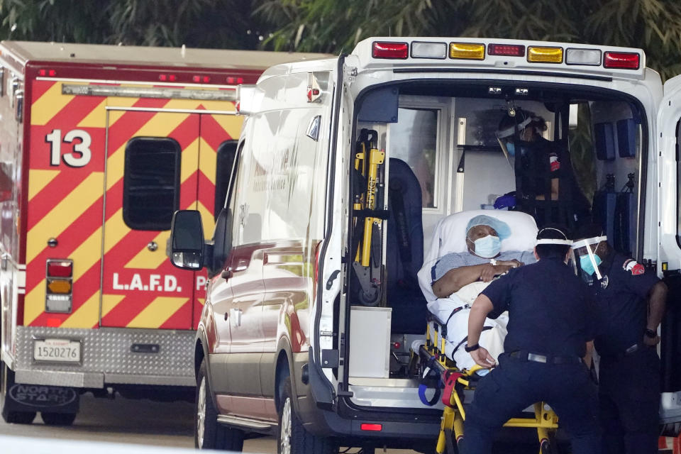 A patient is loaded onto an ambulance outside of the emergency entrance to PIH Health Good Samaritan Hospital Tuesday, Jan. 5, 2021, in Los Angeles. (AP Photo/Marcio Jose Sanchez)