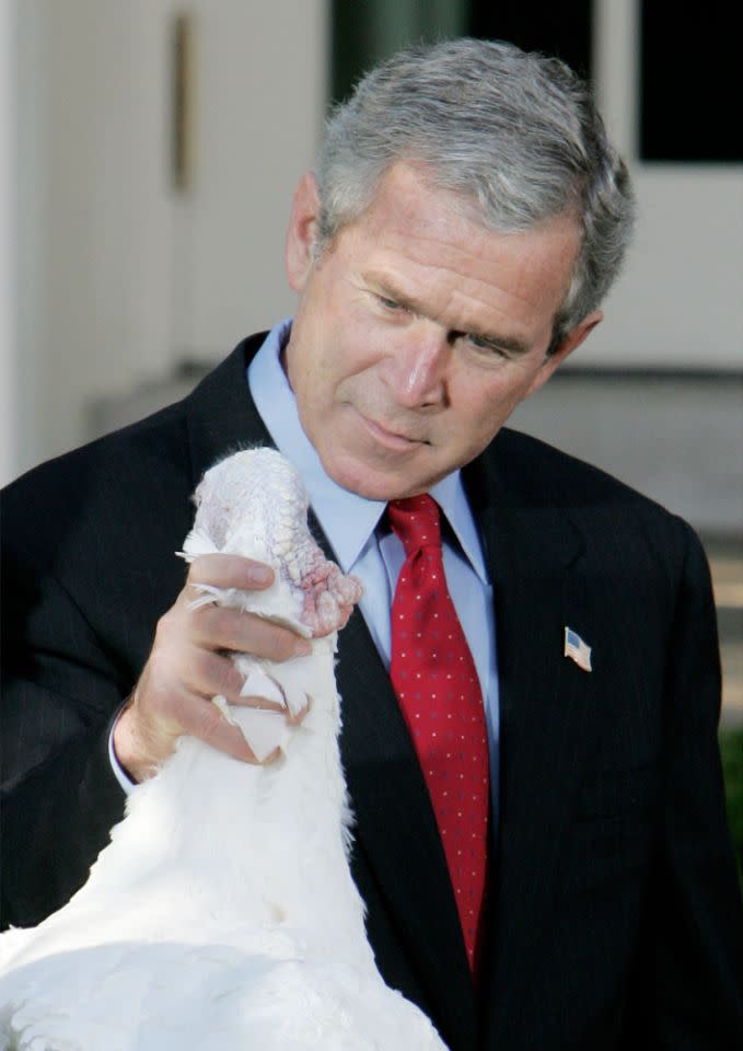 <p>President Geroge W. Bush holds “Biscuits” the turkey by the neck as he participated in the pardoning of the national Thanksgiving turkey, Wednesday, Nov. 17, 2004, in the Rose Garden of the White House. (Photo: Ron Edmonds/AP) </p>
