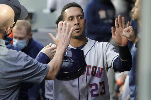 Houston Astros left fielder Michael Brantley (23) is greeted in the dugout after he scored on an RBI-single hit by Yordan Alvarez during the first inning of a baseball game against the Seattle Mariners, Monday, Aug. 30, 2021, in Seattle. (AP Photo/Ted S. Warren)