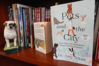 A copy of "Pets and the City" by Dr. Amy Attas, and James Herriot's "All Creatures Great and Small" are displayed on a book shelf in Attas' office at City Pets, Tuesday, April 23, 2024, in New York. (AP Photo/Mary Altaffer)