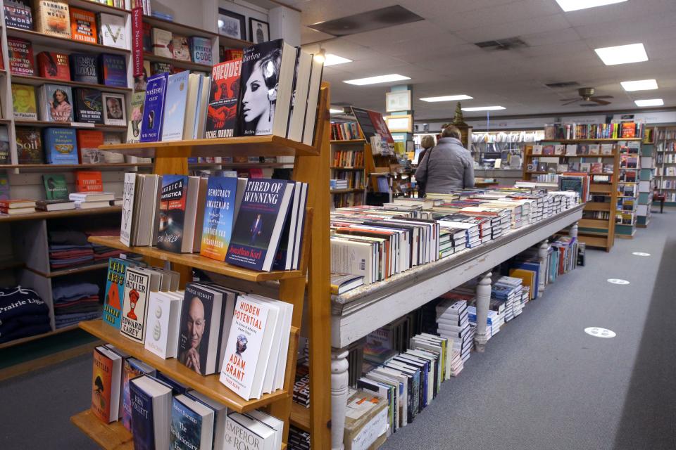 Patrons browse through books at Prairie Lights Monday, Dec. 18, 2023 in Iowa City, Iowa.