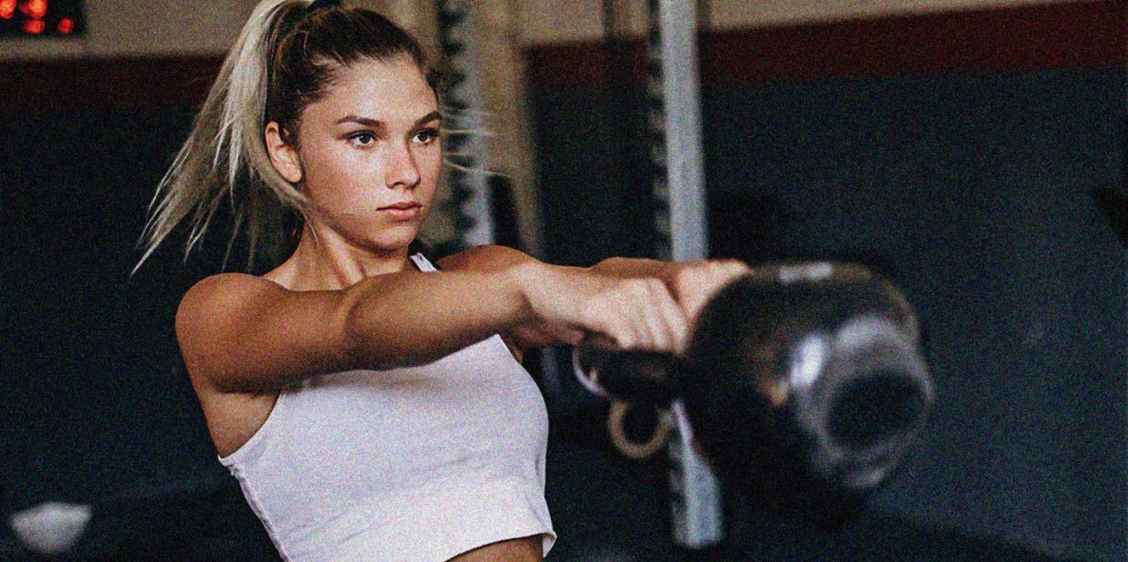 a young woman swinging a kettlebell