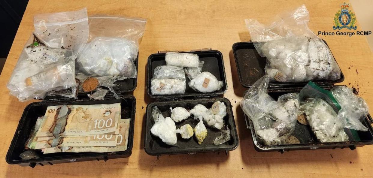 Three cases containing cash and drugs were recovered by Prince George RCMP after getting a tip on April 1, 2024. (Prince George RCMP - image credit)