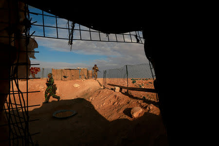 Popular Mobilisation Forces (PMF) fighters hold their weapons as they patrol the Iraqi-Syrian border in Al-Qaim, Iraq. November 26, 2018. REUTERS/Alaa al-Marjani