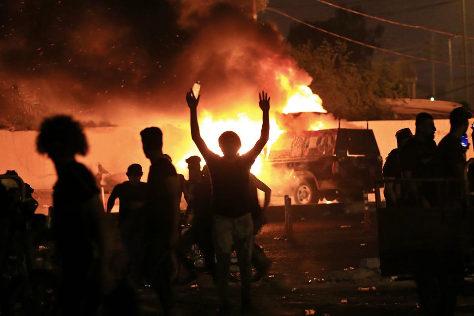 Anti-government protesters burn police vehicles guarding the provincial council during a demonstration in Basra, Iraq, Friday, Oct. 25, 2019. (AP Photo/Nabil al-Jurani)