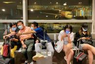 Pasajeros con mascarillas esperan su vuelo en el Aeropuerto Internacional de Kuala Lumpur en Labu, Malasia, el 26 de enero de 2020