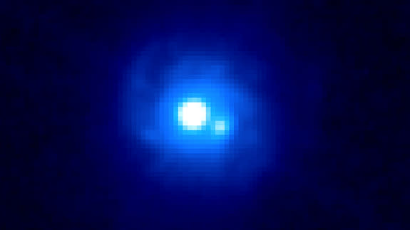 This Hubble Space Telescope image of gravitational lens B0218+357 reveals two bright sources separated by about a third of an arcsecond, each an image of the background blazar. Spiral arms belonging to the lensing galaxy also can be seen. B0218