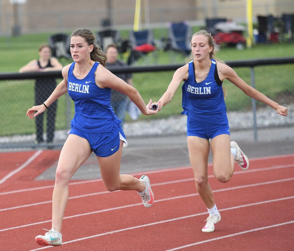 Berlin Brothersvalley's Mercy Sechler, left, takes the baton from Lynndee Ickes for the final leg of the girls 4x100 meter relay and a winning time of 52.69 seconds at the Inter-County Conference track and field championships, May 6, in Loysburg.