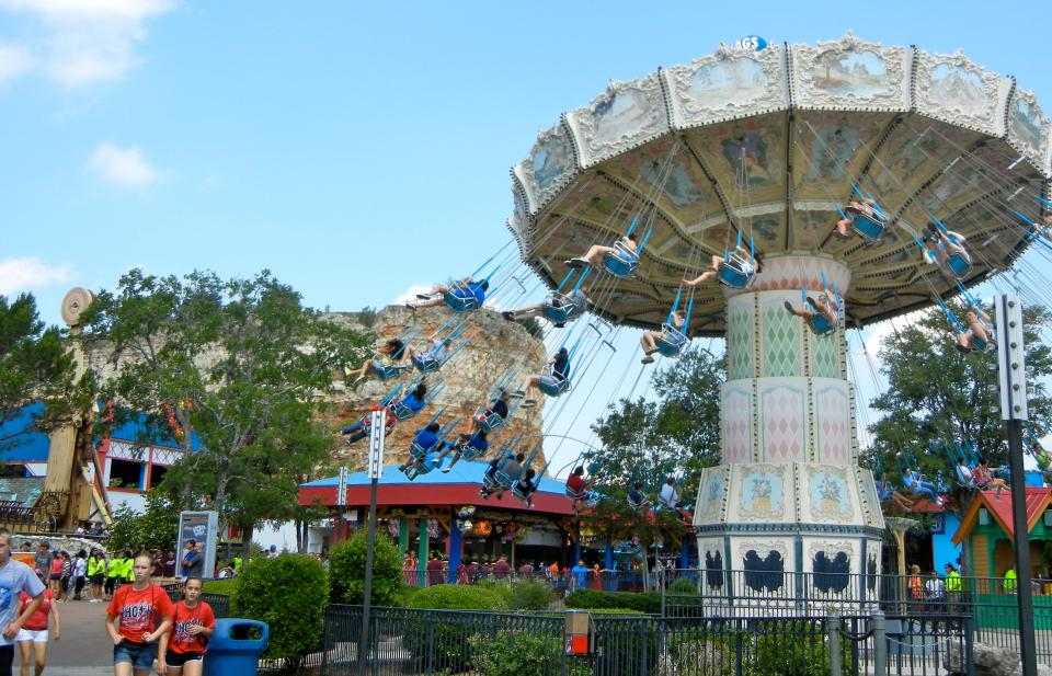 Guests enjoy a swing ride at Six Flags Fiesta Texas in 2012. The park is offering steep discounts to ticket prices online to try to convince guests to brave the heat this summer.