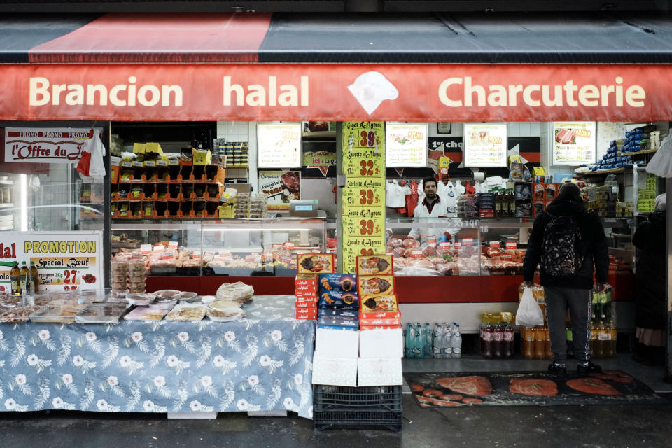 A customer waits to buy halal meat in a butcher shop, in Paris, Wednesday, April 13, 2022. Far-right presidential candidate Marine Le Pen is alarming both Muslims and Jews in France with a pledge to ban the ritual slaughter of animals if elected. (AP Photo/Thibault Camus)