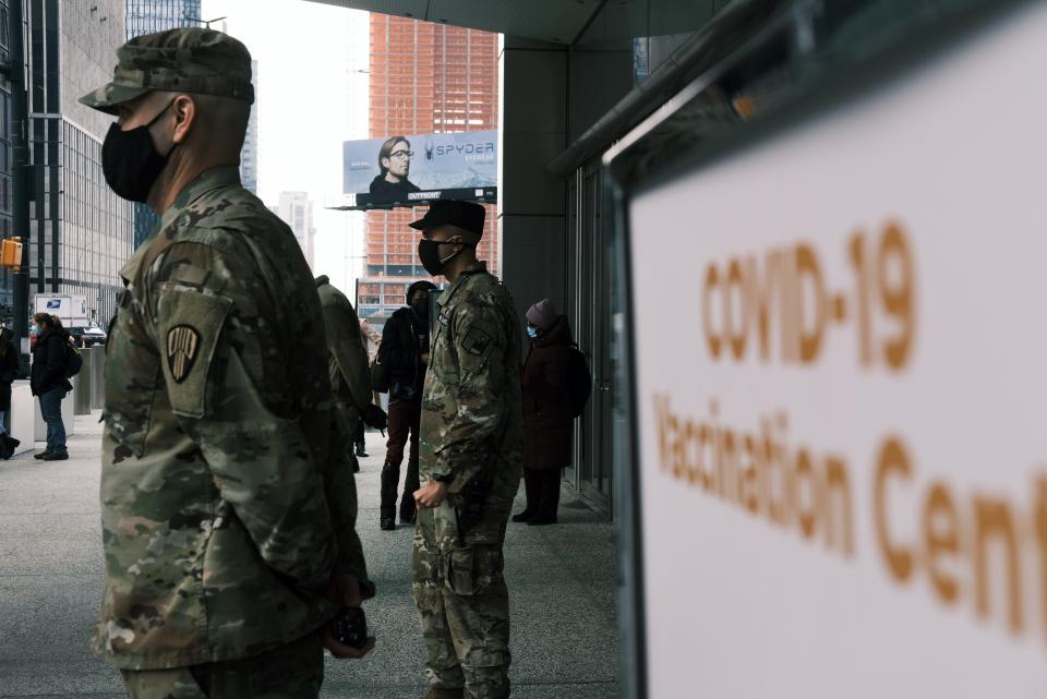 <p>Members of the National Guard assist people at Manhattan’s Javits Center which recently opened as a Covid vaccination site</p> (Getty Images)