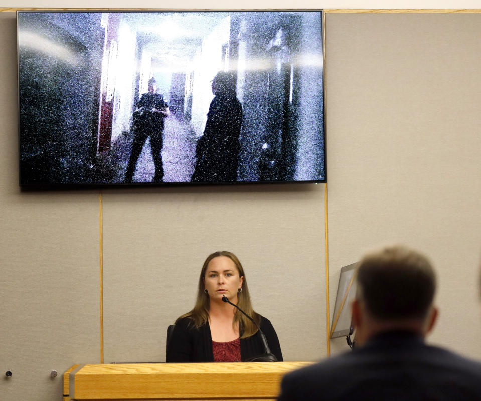 Underneath a body camera image of former Dallas police officer Amber Guyger outside Botham Jean's apartment, Dallas police Sgt. Breanna Valentine responds to questions from Assistant District Attorney Jason Hermus during the trial of Guyger Tuesday, Sept. 24, 2019, in Dallas. Guyger is accused of shooting her unarmed black neighbor in his Dallas apartment. (Tom Fox/The Dallas Morning News via AP, Pool)