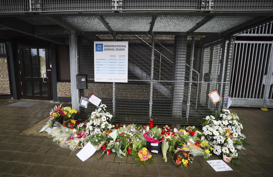 Flowers and candles are placed in front of the entrance to a Jehovah's Witness community center in Hamburg, Germany, Monday, March 13, 2023. Authorities say one victim’s life is still in danger after last week’s shooting at a Jehovah’s Witness hall in Hamburg in which a former member of the congregation killed six people and then himself. (Christian Charisius/dpa via AP)