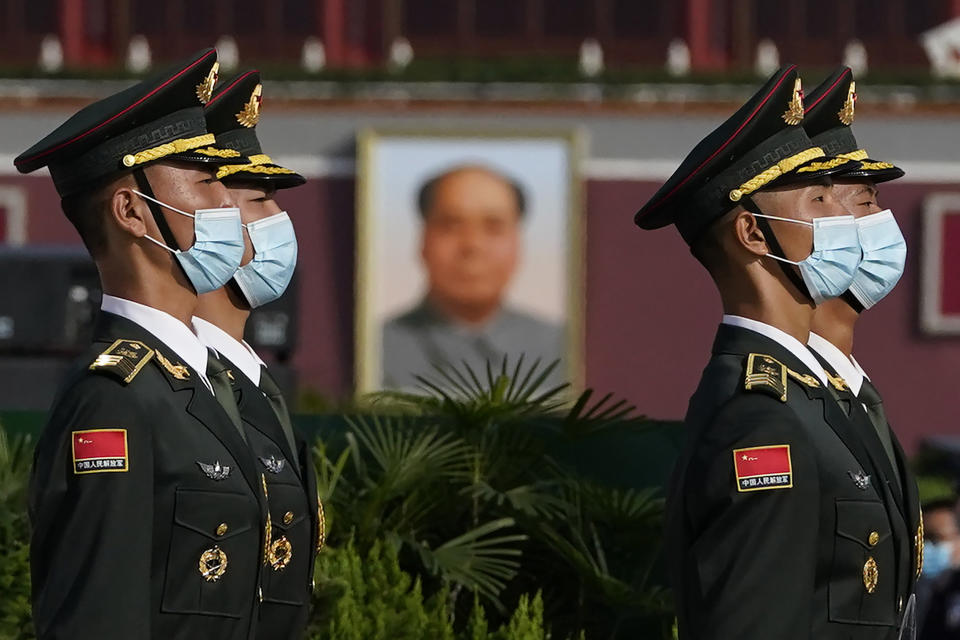 Chinese honor guards wearing masks to protect agains the coronavirus are seen near the portrait of late leader Mao Zedong during a ceremony held at the Monument to the People's Heroes on Tiananmen Square in Beijing on Wednesday, Sept. 30, 2020. Negative perceptions of China have increased sharply in many of the world's advanced economies, especially in Australia and the U.K., a new survey from the Pew Research Center showed Tuesday, Oct. 6, 2020. (AP Photo/Ng Han Guan)