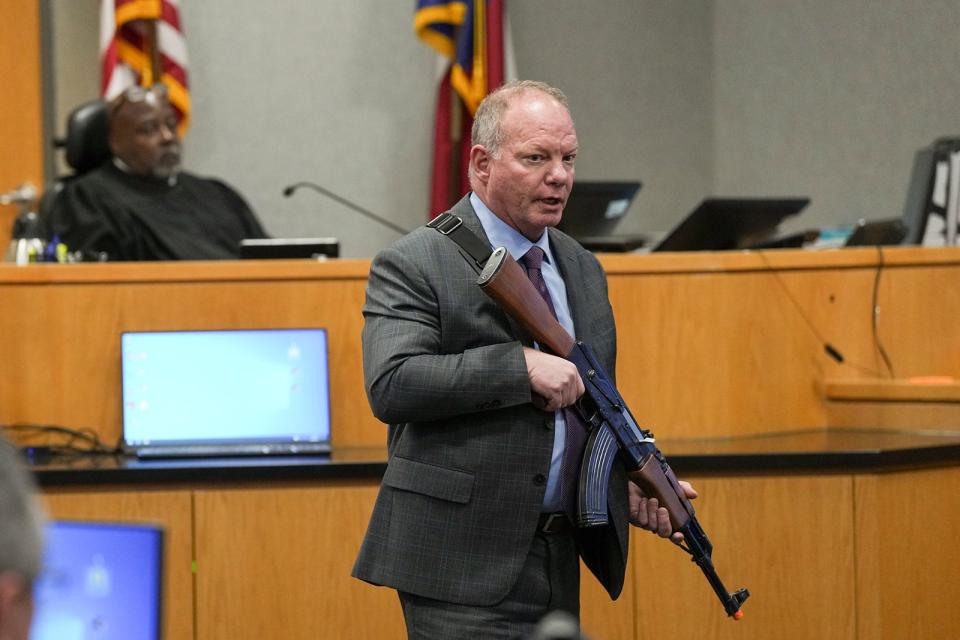 Defense attorney Doug O'Connell uses a toy rifle to demonstrate how a protester was holding a weapon while questioning a witness during the first day of Daniel Perry's murder trial in the slaying of Garrett Foster.