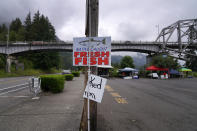 Native tribesmen and women sell fresh, smoked and canned salmon in a parking lot near the Columbia River on Friday, June 17, 2022, in Cascade Locks, Ore. (AP Photo/Jessie Wardarski)