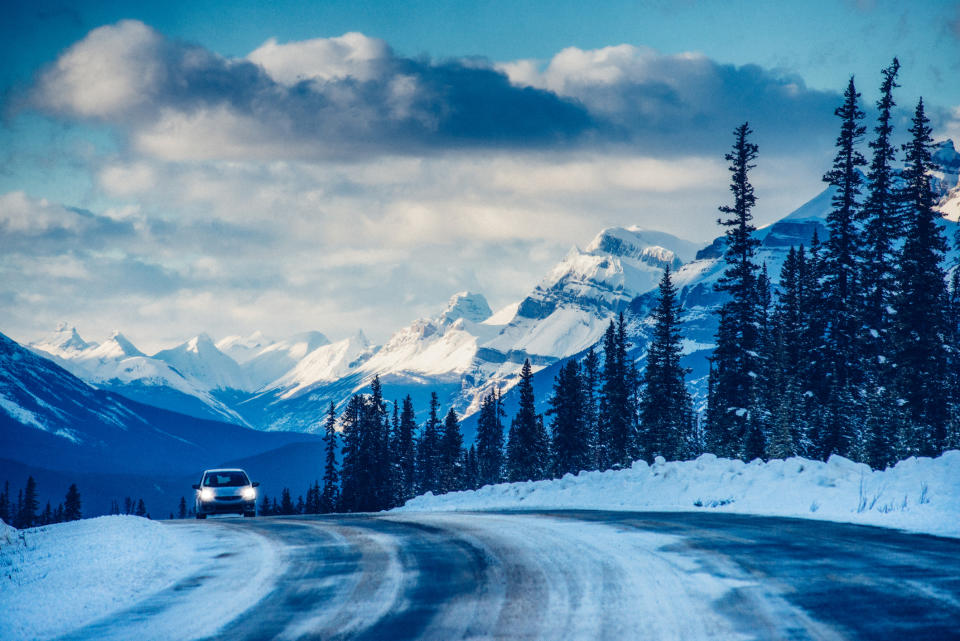 A Canadian skyline with a car driving through the snow