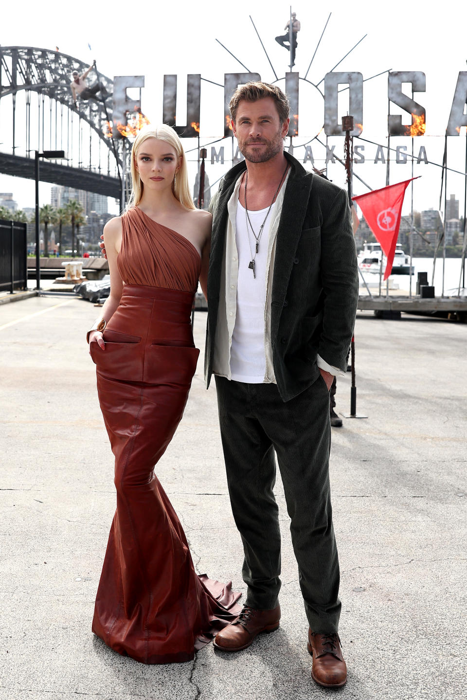 Anya Taylor-Joy stands next to Chris Hemsworth as they pose for a photo shoot.