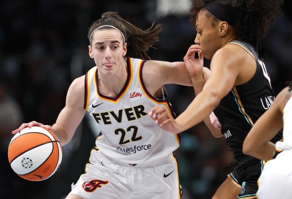 Indiana Fever guard Caitlin Clark drives to the basket under pressure from New York Liberty forward Betnijah Laney-Hamilton