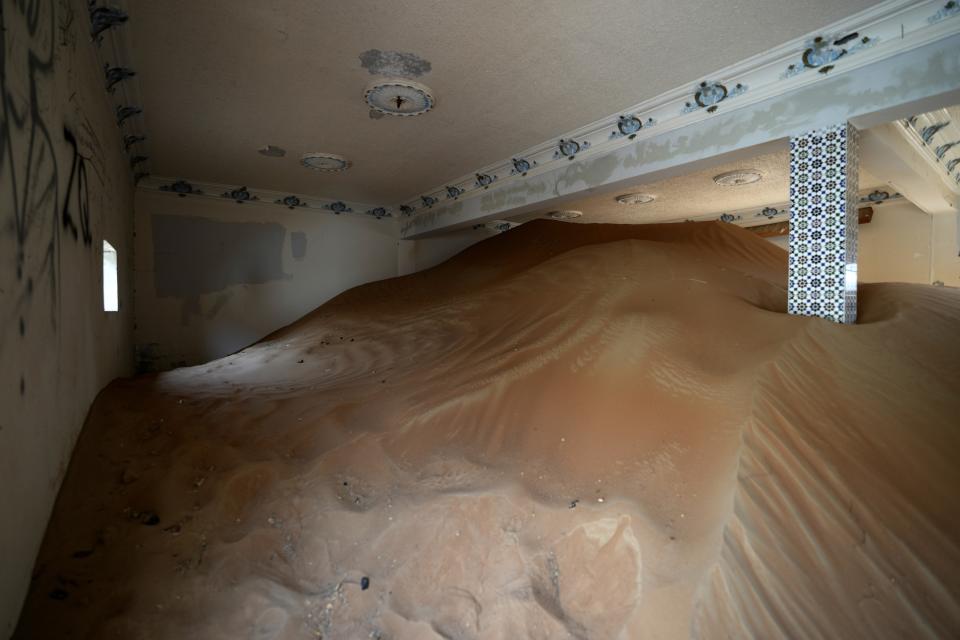 Sand is piled in a house at the Bedouin village of al-Ghuraifabout 100 km, 62 miles, southeast of Sharjah, United Arab Emirates, Sunday, July 9, 2023. Built-in the 1970s, the village was abandoned two decades later as oil wealth transformed the country into a global hub of commerce and tourism, home to the futuristic cities of Dubai and Abu Dhabi. (AP Photo/Kamran Jebreili)