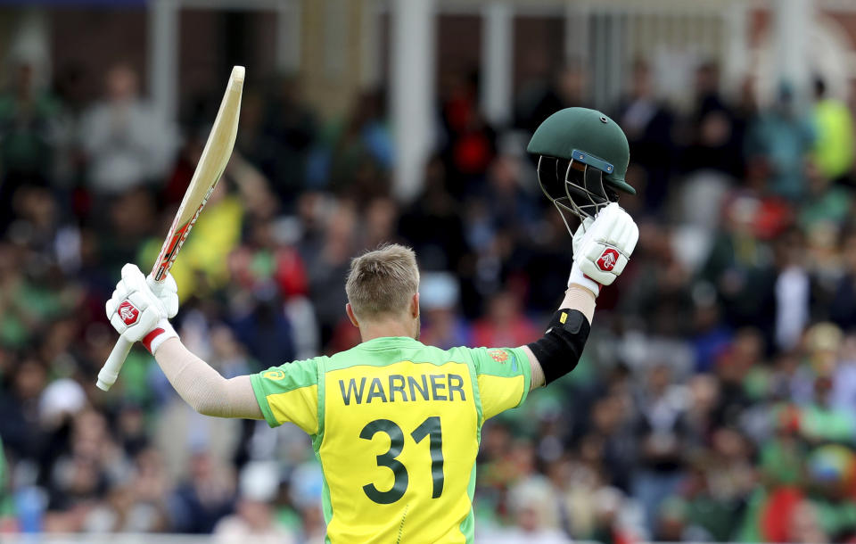 Australia's David Warner raises his bat and helmet to celebrate scoring a century during the Cricket World Cup match between Australia and Bangladesh at Trent Bridge in Nottingham, Thursday, June 20, 2019. (AP Photo/Rui Vieira)