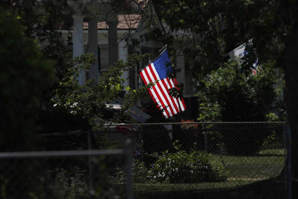 A U.S. flag is lit by the midmorning sun on a neighborhood street in Saginaw, Mich., on Monday, June 29, 2020. President Donald Trump won Saginaw county by just over 1,000 votes in 2016, capitalizing on the rusting industrial city's frustrations and its dislike of Democrat Hillary Clinton. (AP Photo/Charles Rex Arbogast)