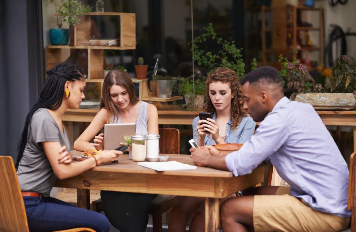 people at table with phones