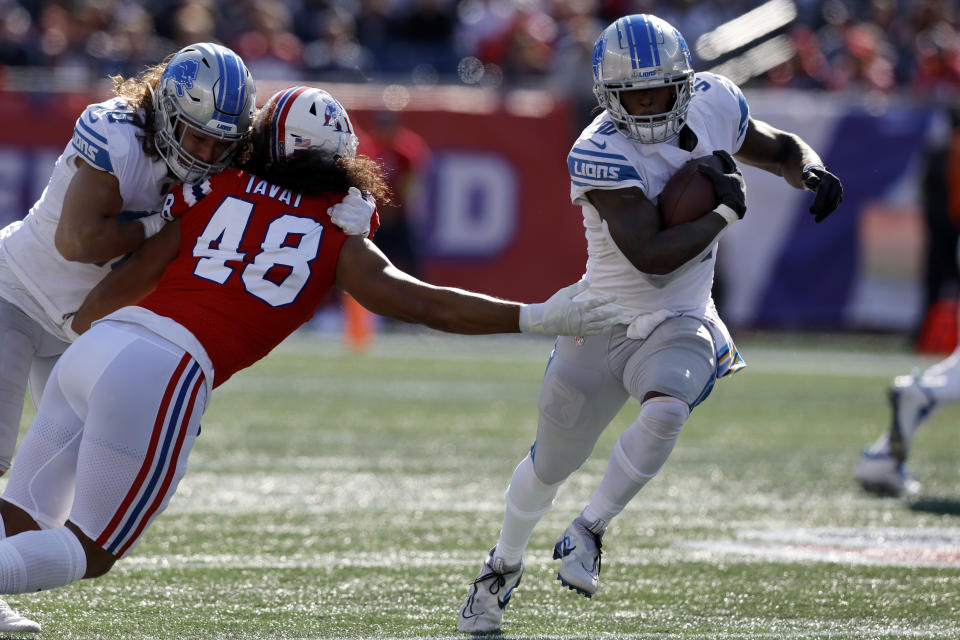 Detroit Lions running back Jamaal Williams, right, runs with the ball as New England Patriots linebacker Jahlani Tavai (48) tries to defend while being hit by Lions tight end T.J. Hockenson, left, during the second half of an NFL football game, Sunday, Oct. 9, 2022, in Foxborough, Mass. (AP Photo/Michael Dwyer)