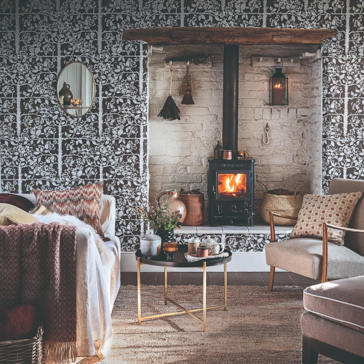 A living room with a fireplace and a floral wallpaper. 