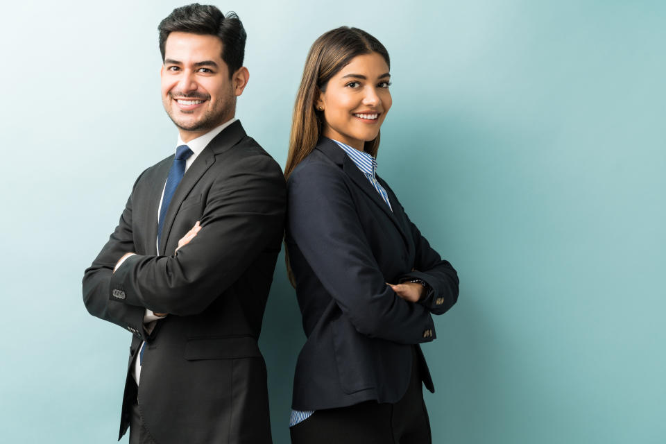 Confident professionals in suit standing against isolated background