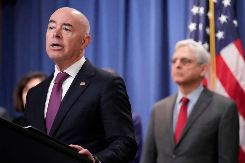 Secretary of Homeland Security Alejandro Mayorkas speaks with reporters during a news conference at the Department of Justice on Dec. 6, 2023, in Washington, as Attorney General Merrick Garland looks on.