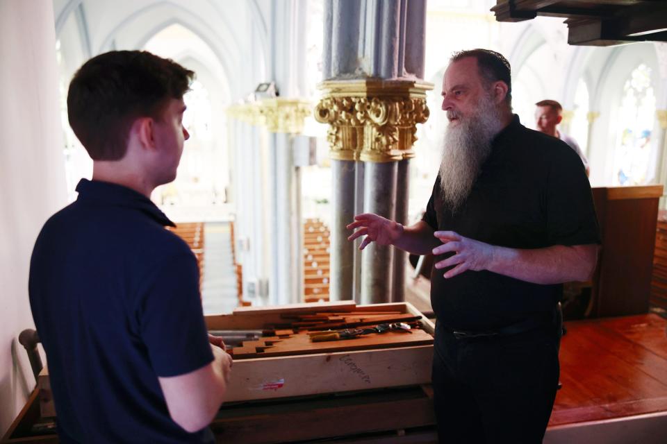 The Rev. Blair Gaynes, right, talks with Zack Emerson of William H. Longmore & Associates from Lakeland at the Basilica of The Immaculate Conception during the organ's move.