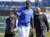 Retired NBA All-Star Tracy McGrady points to the catcher after throwing a pitch into the dirt during a workout at the Sugar Land Skeeters baseball stadium Wednesday, Feb. 12, 2014, in Sugar Land, Texas as manager Gary Gaetti, left, and former major league pitcher Scipio Spinks stand near. McGrady hopes to tryout as a pitcher for the independent Atlantic League Skeeters. (AP Photo/Pat Sullivan)