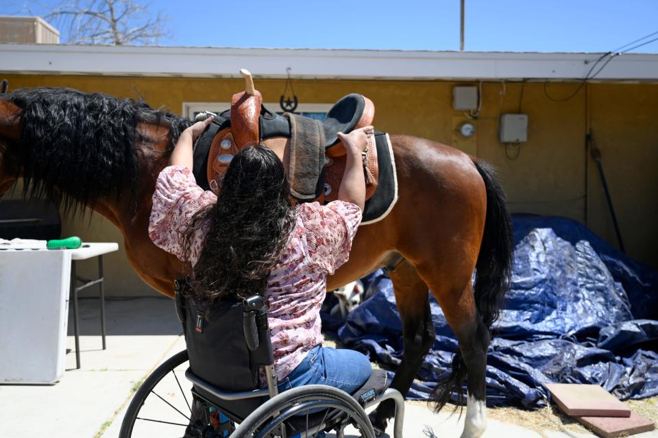 Army Veteran Clarice Sykes, 28, removes the saddle off her horse Denali for grooming on Thursday, April 25, 2024 in Victorville. Clarice suffered a freak accident in July 2018 leaving her without legs but continues to pursue her passion with horses and intends to open her own ranch where she will cater to people of all ages, but especially to children and veterans with disabilities.