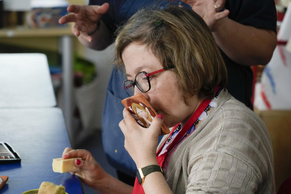 Nadia Notarantonio kisses a ceramic tablet adorned with an angel as she prepares first communion favors inside the Chicco community of L'Arche, an International charity that helps people with intellectual disabilities, in Ciampino, near Rome, Wednesday, March 22, 2023. The findings of expert reports commissioned by L’Arche itself reveal that their founder, Jean Vanier, perverted Catholic doctrine to justify his own sexual compulsions and abuse women and that the movement he created had at its core a secret, a mystical-sexual “sect” founded for the precise purpose of hiding the sect’s deviant activities from church authorities. (AP Photo/Gregorio Borgia)