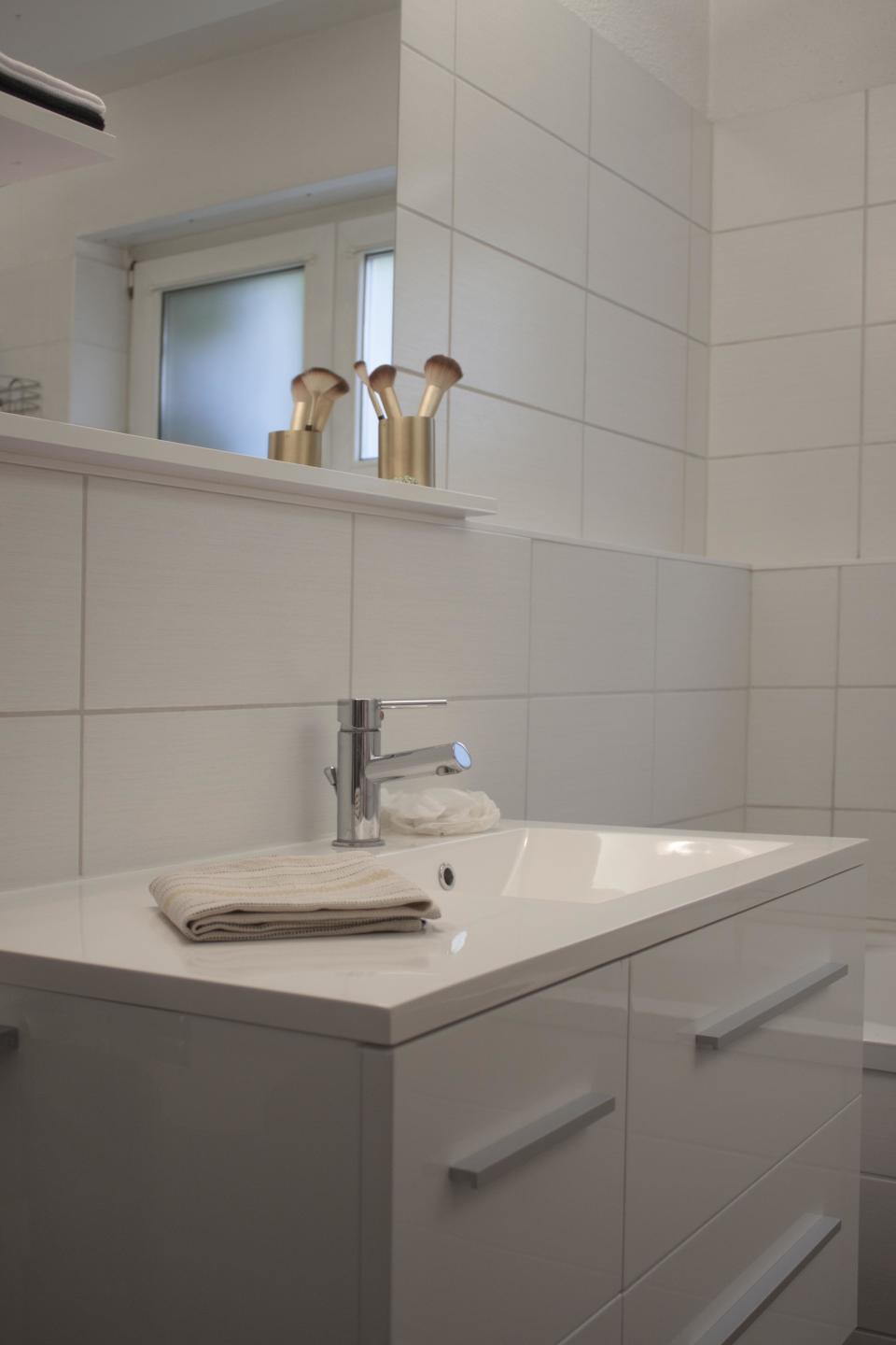 The bathroom employs simple fixtures and white walls, and a few floating shelves that lay flush against the left side of the mirror for extra bits and bobs. The convenient ledge that edges the entire bathroom is typical of German bathrooms—it’s where all the pipes are!
