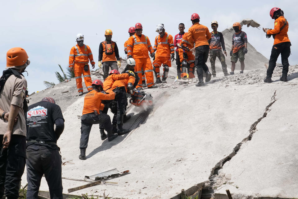 Rescuers cut through cement to recover the body of an earthquake victim from under the rubble of a collapsed building in Cianjur, West Java, Indonesia,Tuesday, Nov. 22, 2022. Rescuers on Tuesday struggled to find more bodies from the rubble of homes and buildings toppled by an earthquake that killed a number of people and injured hundreds on Indonesia's main island of Java. (AP Photo/Tatan Syuflana)
