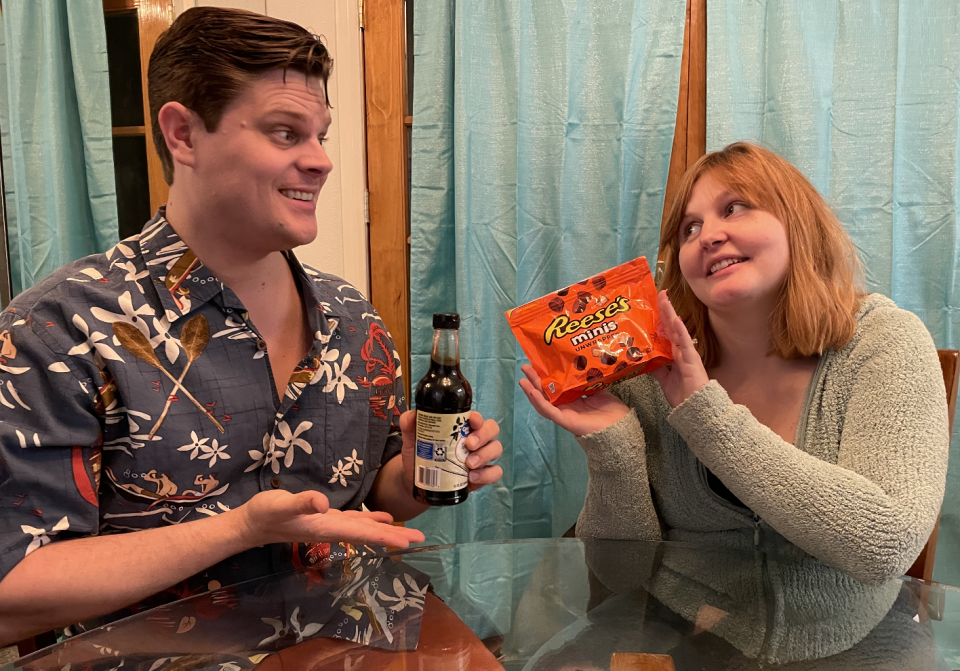 author and zach holding up a bag of reeses minis and a bottle of soy sauce